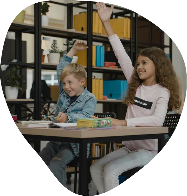 Primary school students raising their hands in class
